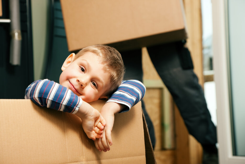 Young boy smiling inside a moving box