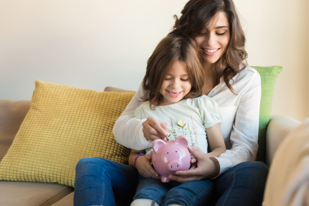 Mom and daughter saving money in a piggy bank