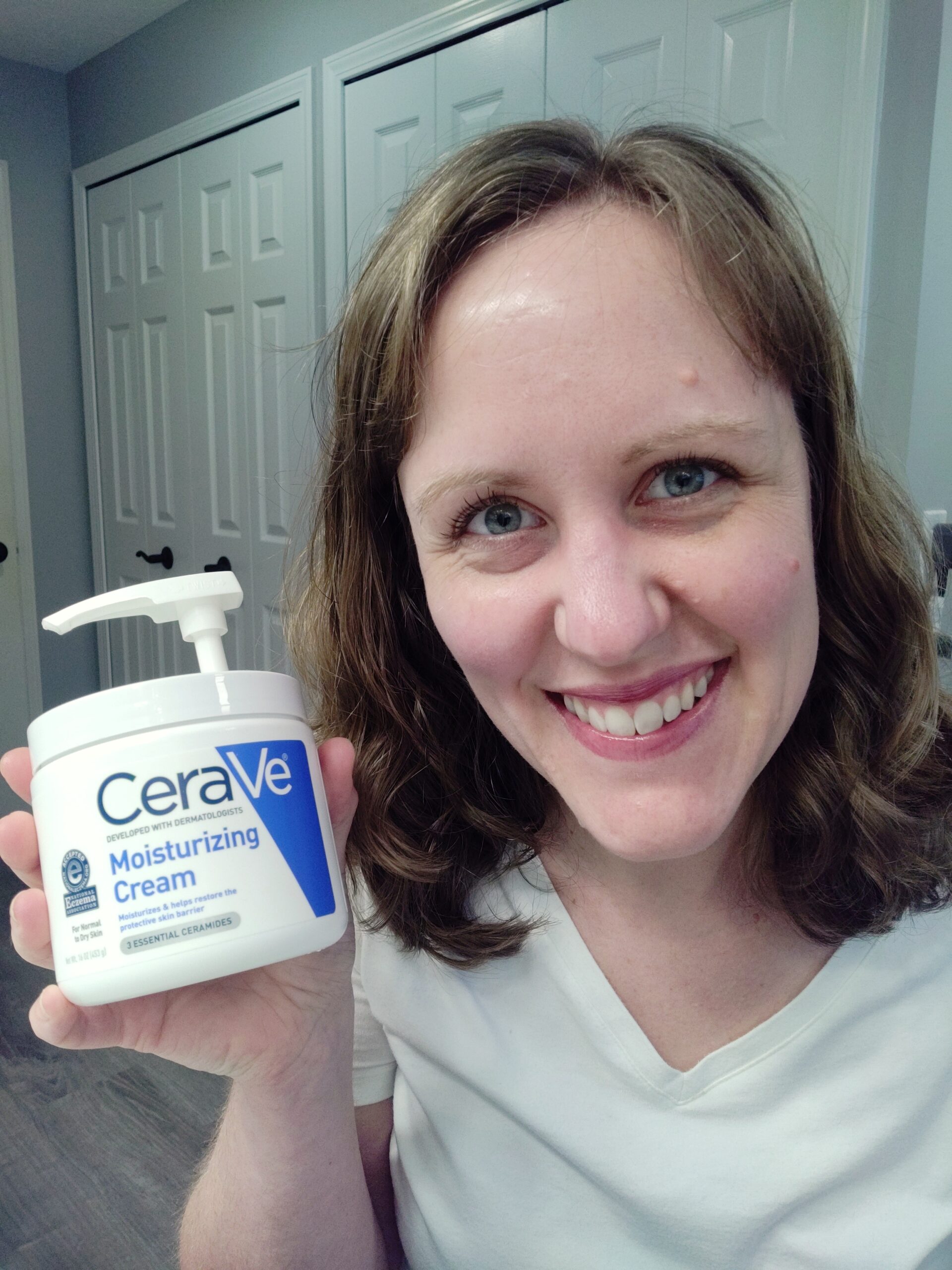 Woman holding tub of Cerave moisturizing cream