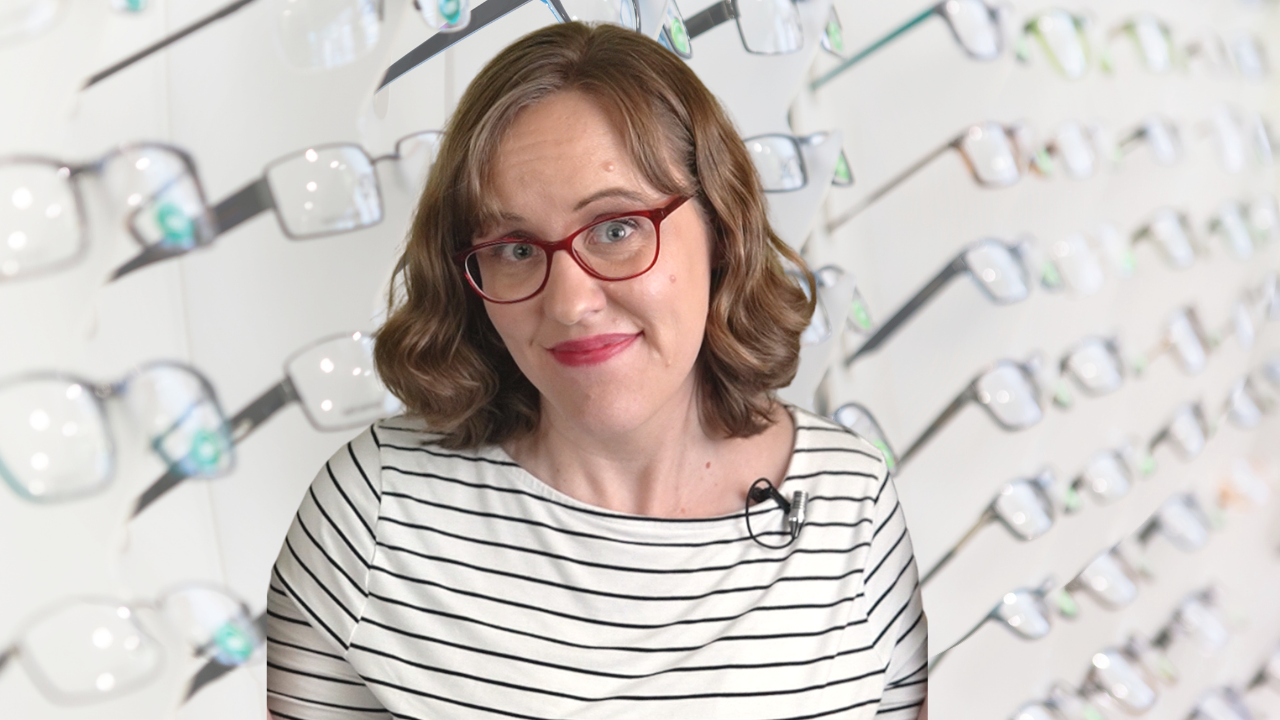 Woman in front of rack of eyeglasses